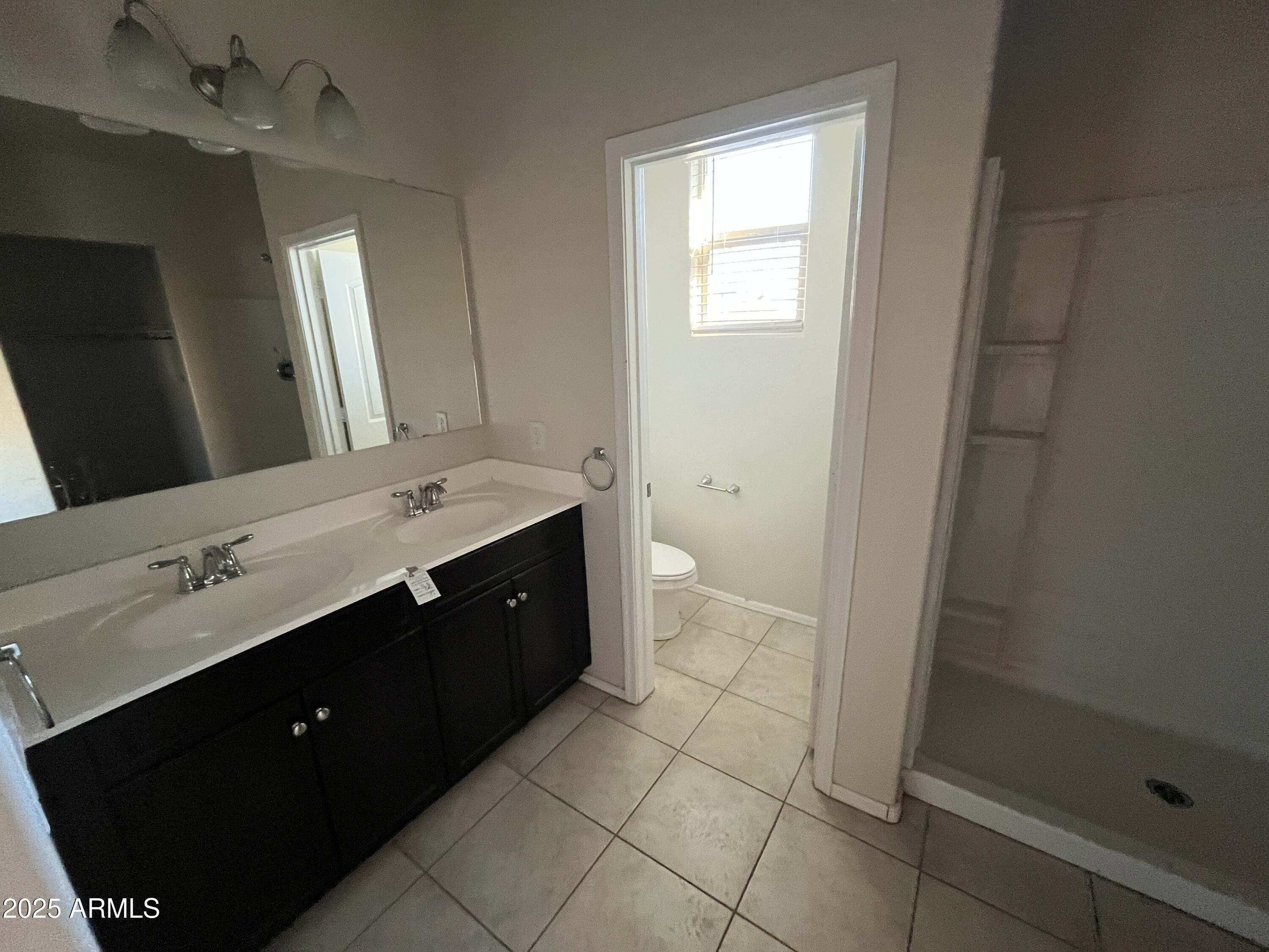 30968 West Picadilly Road Buckeye, AZ 85396 - Photo 10 of 21 a spacious bathroom with a double vanity sink a mirror and a bathtub