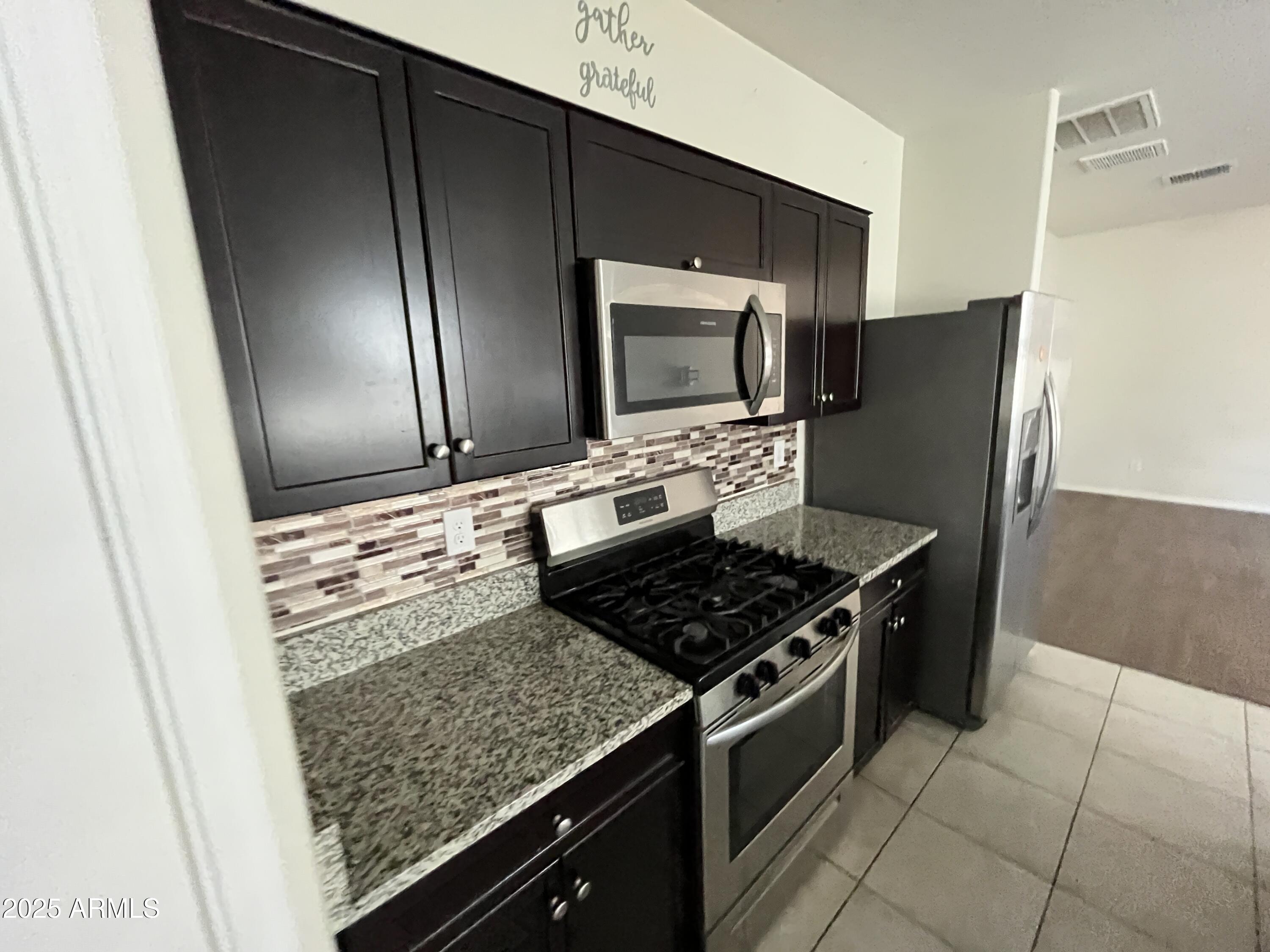 30968 West Picadilly Road Buckeye, AZ 85396 - Photo 6 of 21 a kitchen with stainless steel appliances granite countertop a refrigerator and a stove