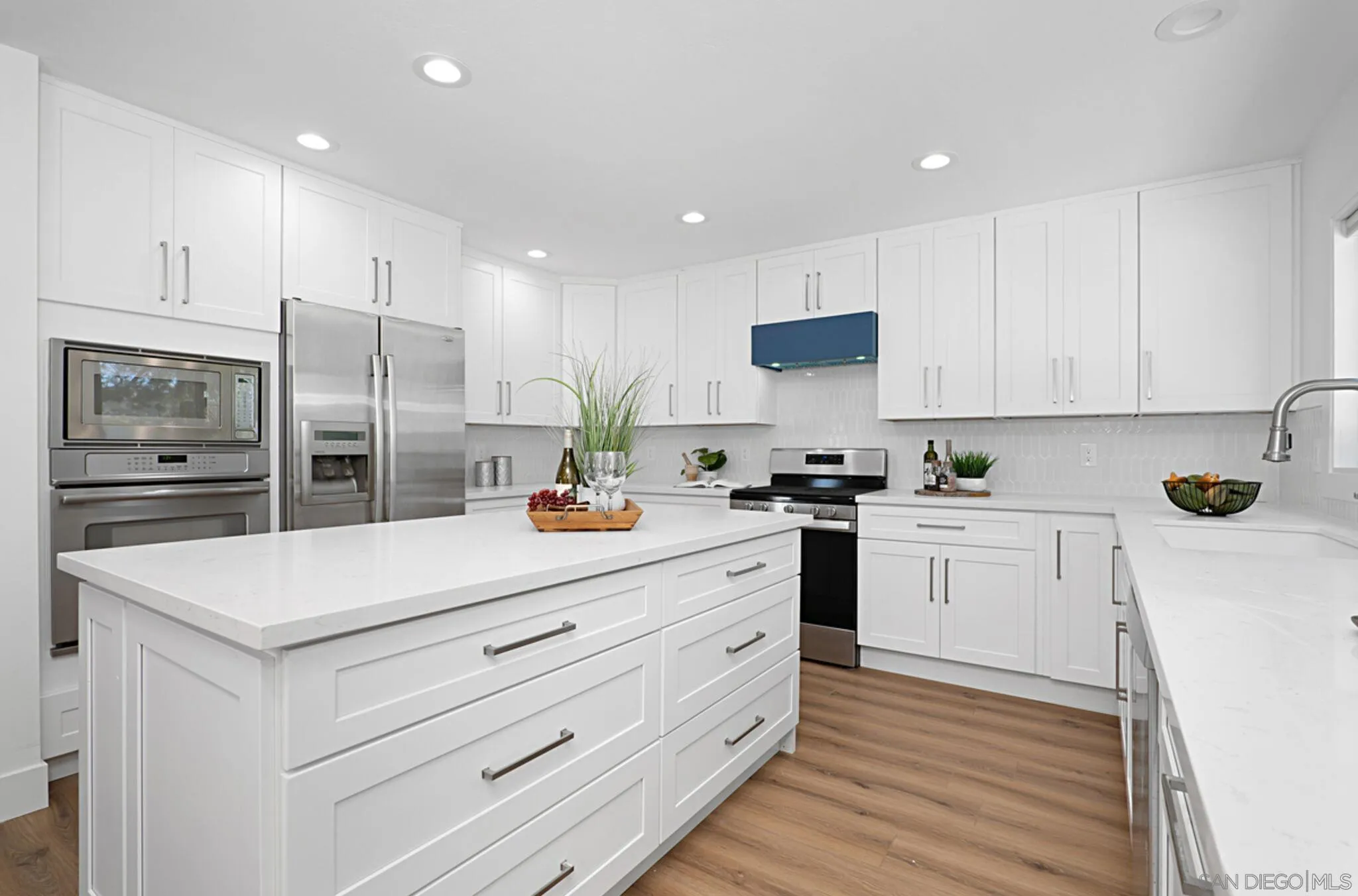 2282 Morgan Road Carlsbad, CA 92008 - Photo 9 of 28 a kitchen with stainless steel appliances white cabinets and wooden floor