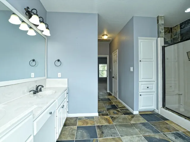 a spacious bathroom with a double vanity sink shower and a mirror
