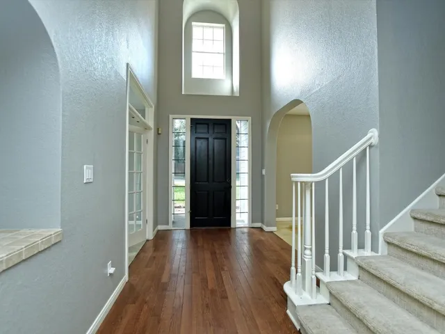 a view of a hallway with wooden floor and staircase