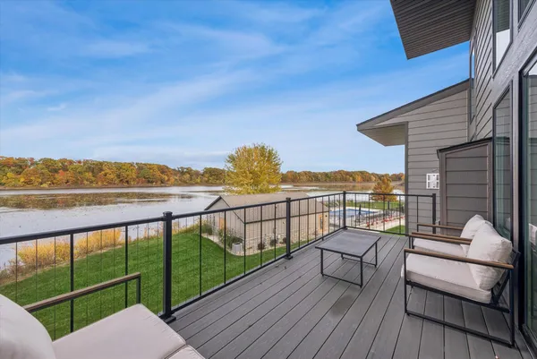 a view of a balcony with wooden floor next to a yard