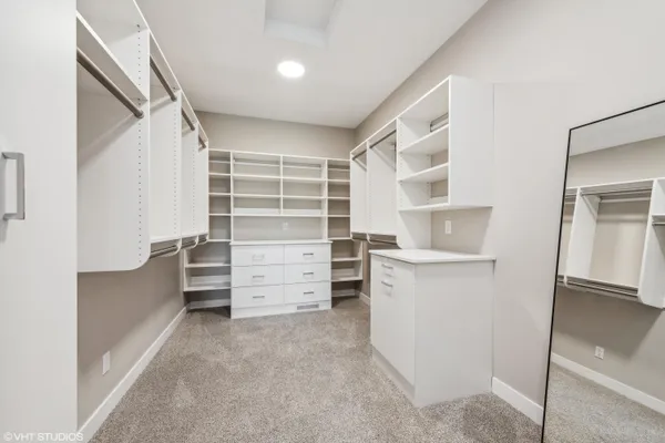 a view of walk in closet with clothes and shoes