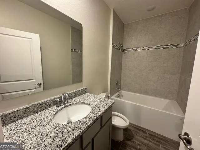 a view of a room with wooden floor and bathroom
