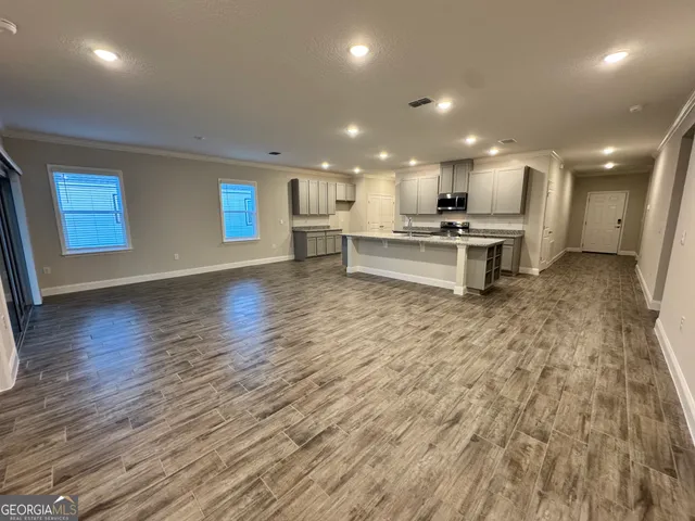 a view of kitchen with wooden floor and chairs