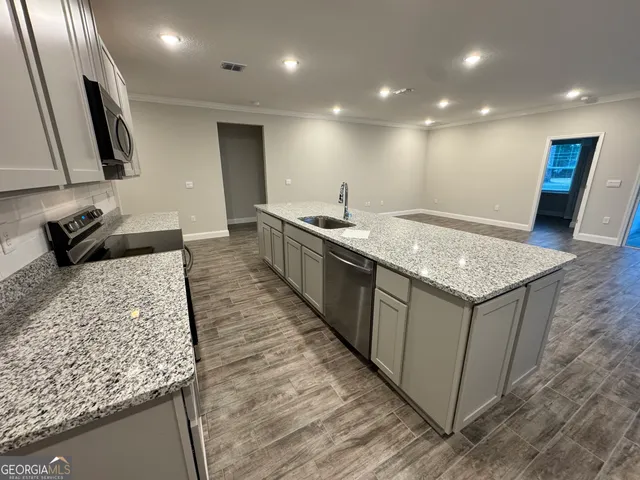 a kitchen with granite countertop sink and refrigerator
