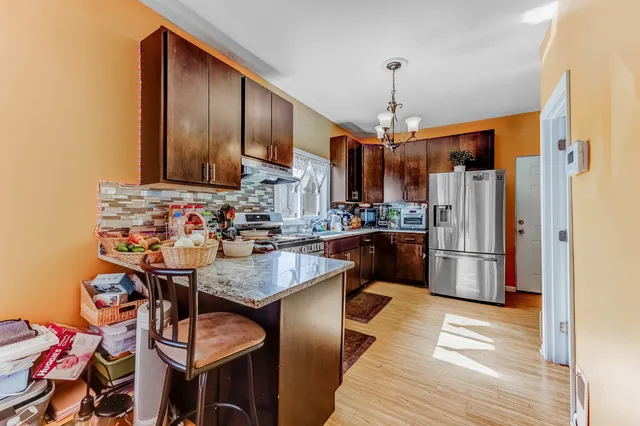 a kitchen with stainless steel appliances granite countertop a sink refrigerator and cabinets