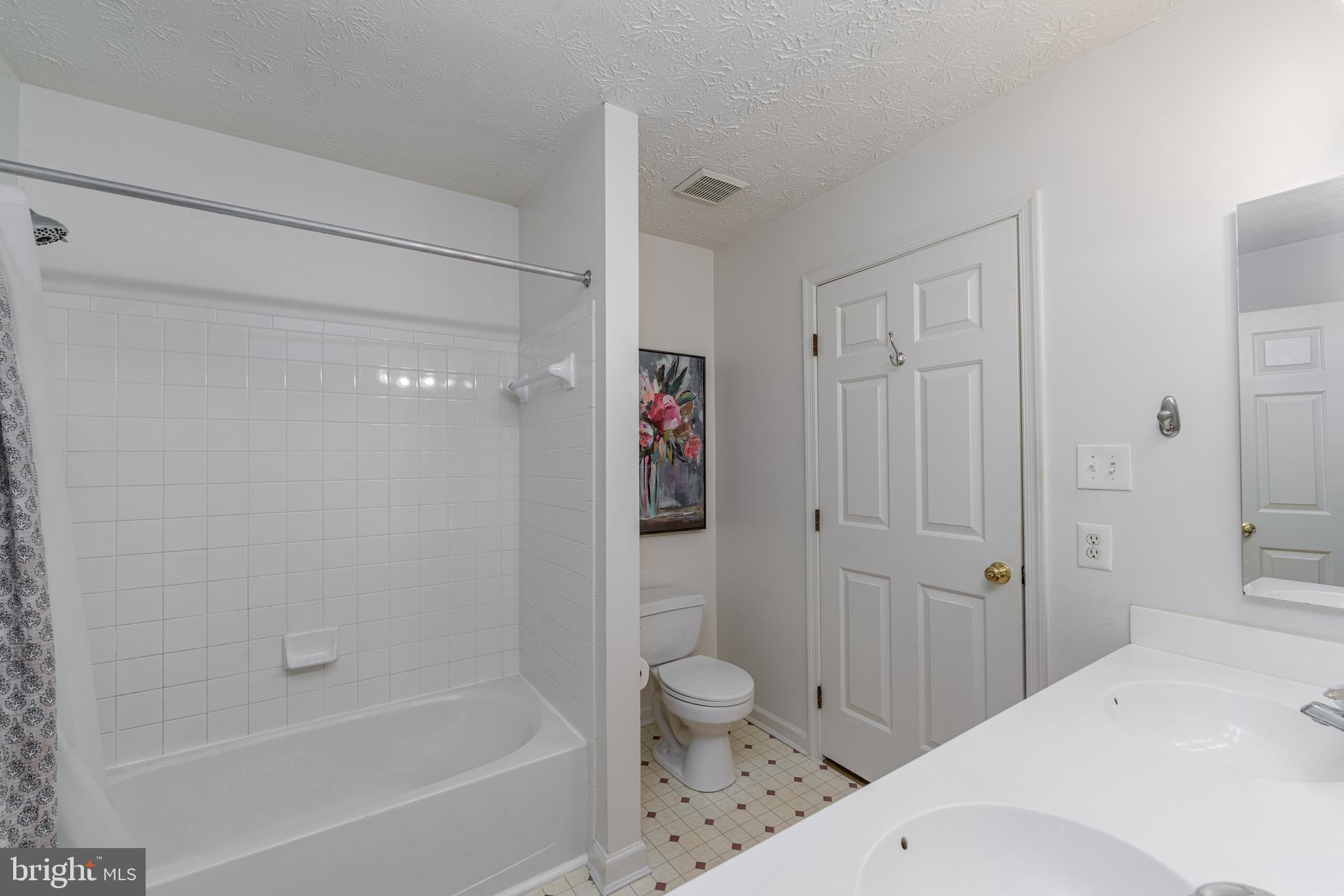8303 Spadderdock Way Laurel, MD 20724 - Photo 13 of 25 a bathroom with a bathtub shower sink vanity and toilet