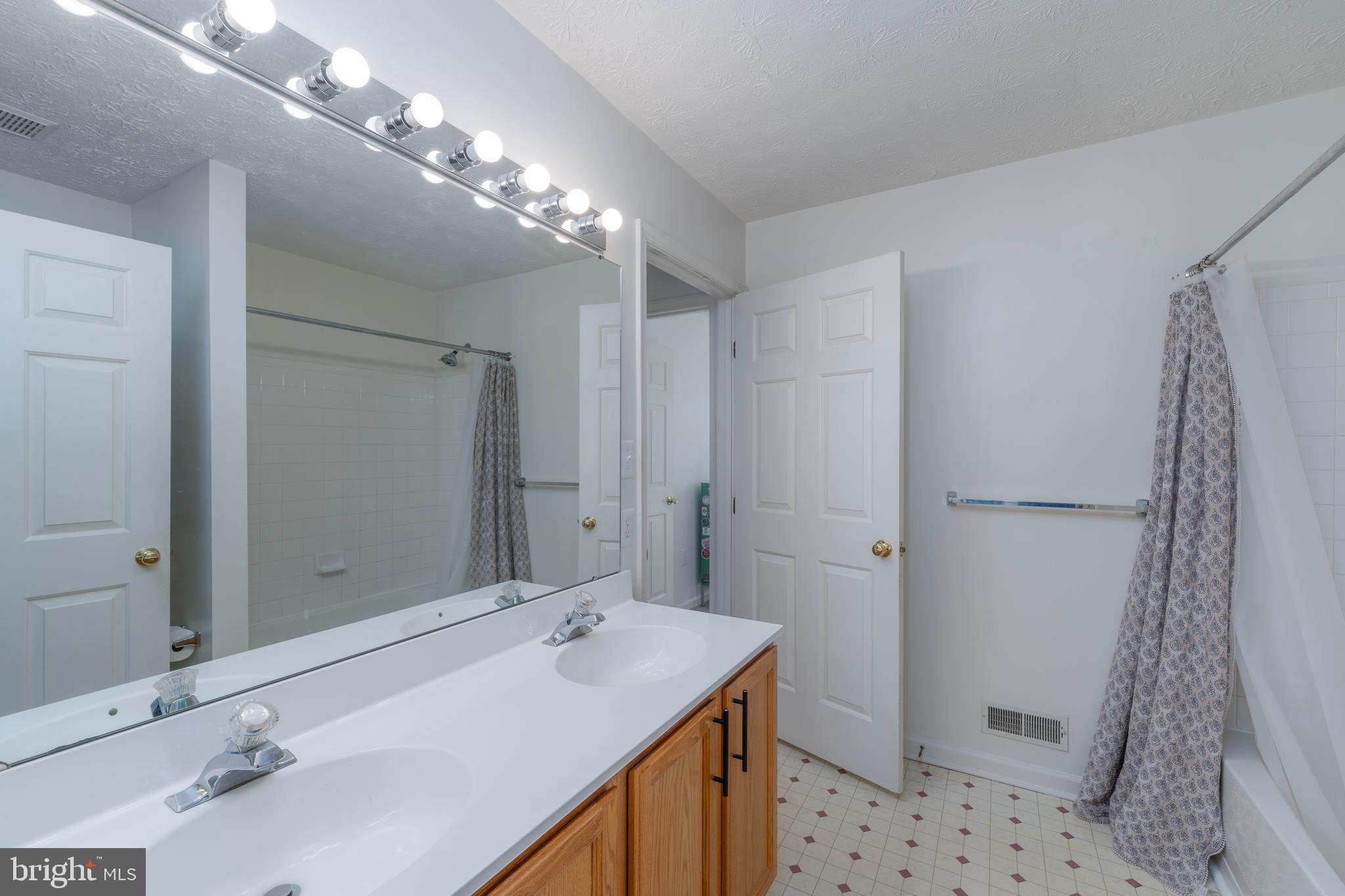 8303 Spadderdock Way Laurel, MD 20724 - Photo 14 of 25 a bathroom with a double vanity sink mirror and shower