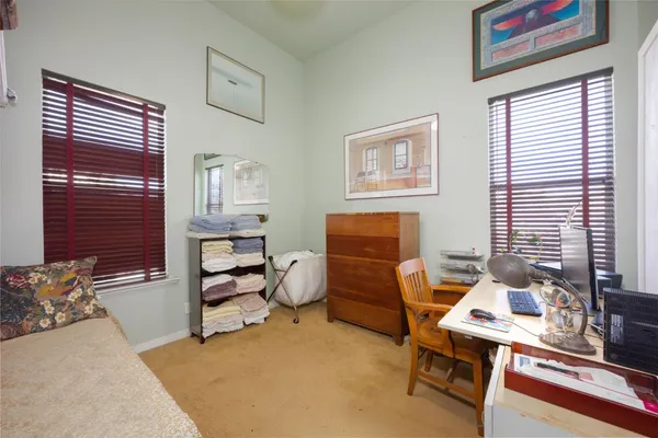 a bedroom with a bed and a lamp on dresser