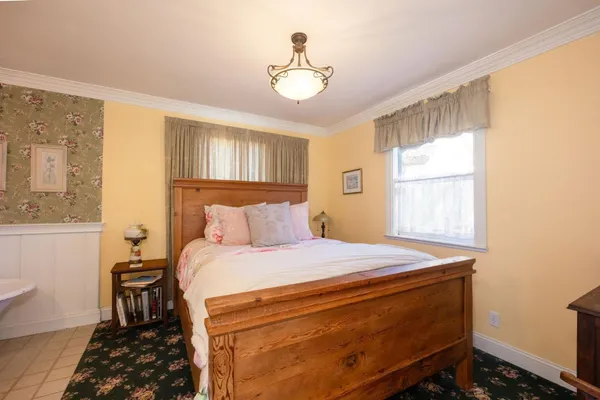 a view of a hallway with wooden floor and a bathroom