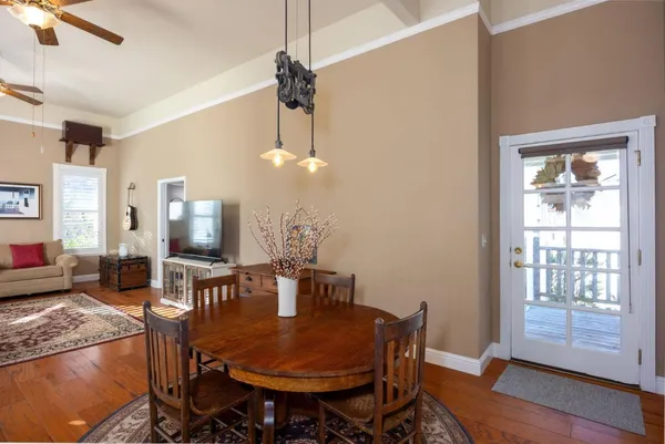 a dining room with furniture a chandelier and wooden floor