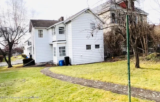a view of a house with a yard patio and fire pit