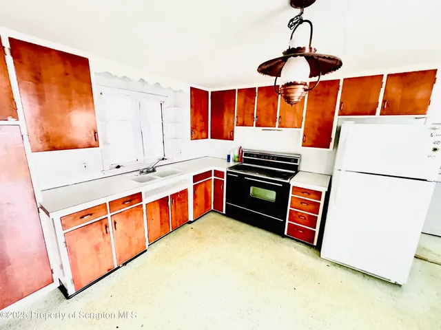 a kitchen with stainless steel appliances kitchen island a stove a sink and a refrigerator