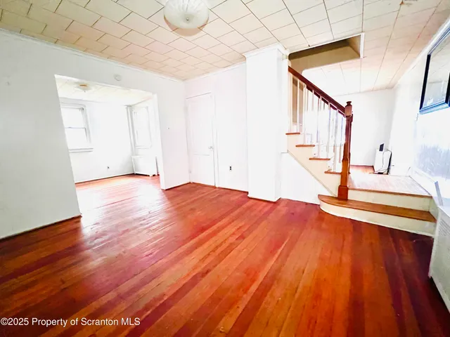 a view of a room with wooden floor and staircase