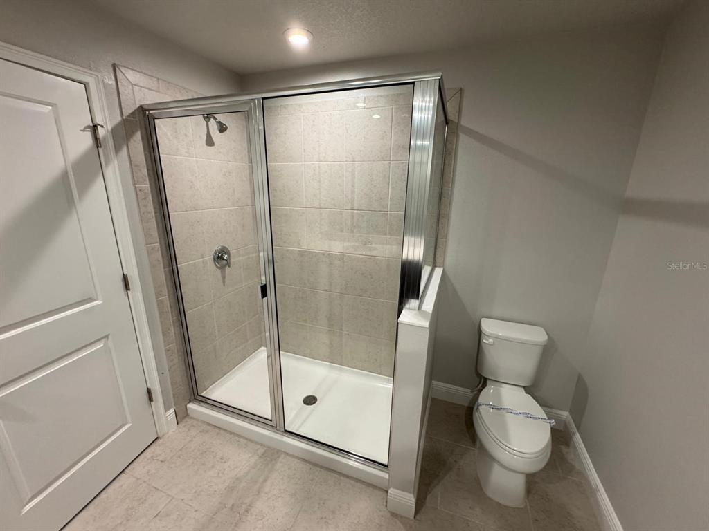 5912 Grand Sonata Avenue Lutz, FL 33558 - Photo 19 of 36 a bathroom with a shower and a toilet