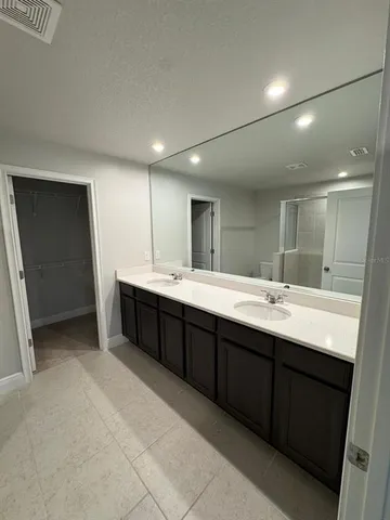 a bathroom with a double vanity sink toilet mirror and shower