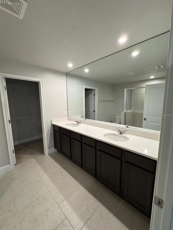 5912 Grand Sonata Avenue Lutz, FL 33558 - Photo 23 of 36 a spacious bathroom with a double vanity sink and a mirror