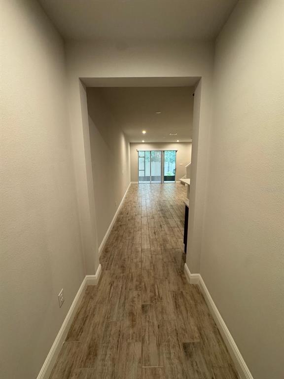 5912 Grand Sonata Avenue Lutz, FL 33558 - Photo 3 of 36 a view of a hallway with wooden floor