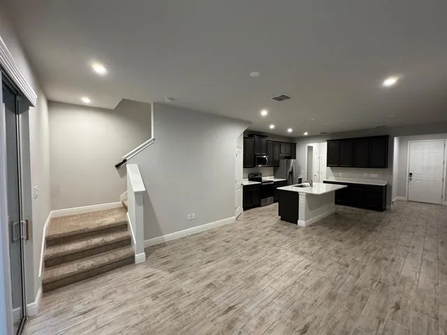a view of kitchen with stainless steel appliances kitchen island wooden cabinets and refrigerator
