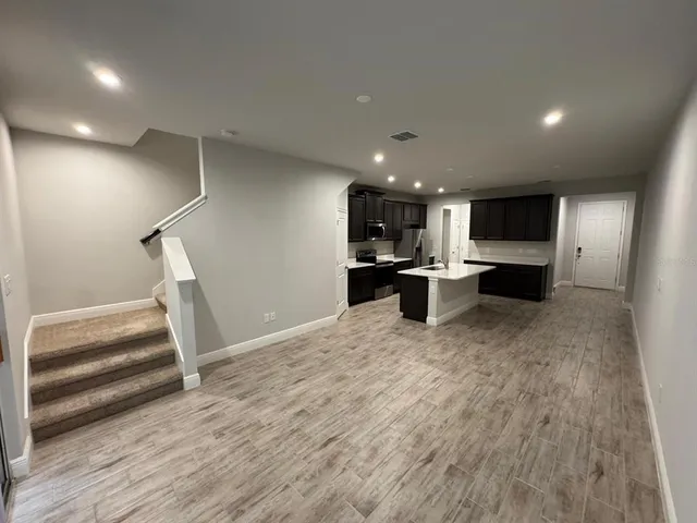a open kitchen with white cabinets and stainless steel appliances