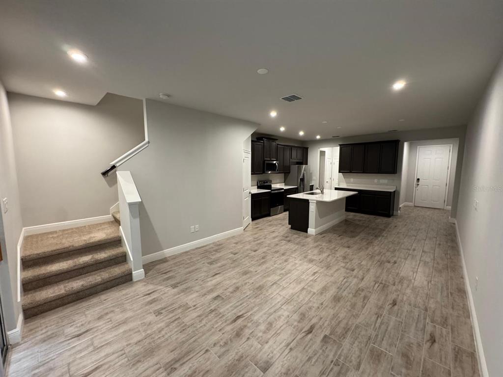 5912 Grand Sonata Avenue Lutz, FL 33558 - Photo 6 of 36 a open kitchen with white cabinets and stainless steel appliances