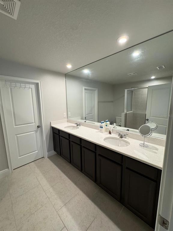 5912 Grand Sonata Avenue Lutz, FL 33558 - Photo 7 of 36 a bathroom with a double vanity sink a and mirror