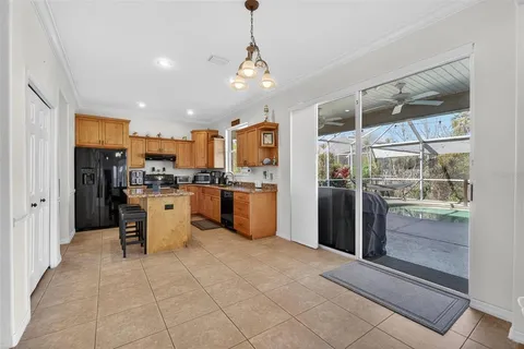 a kitchen with stainless steel appliances kitchen island granite countertop a refrigerator and a sink