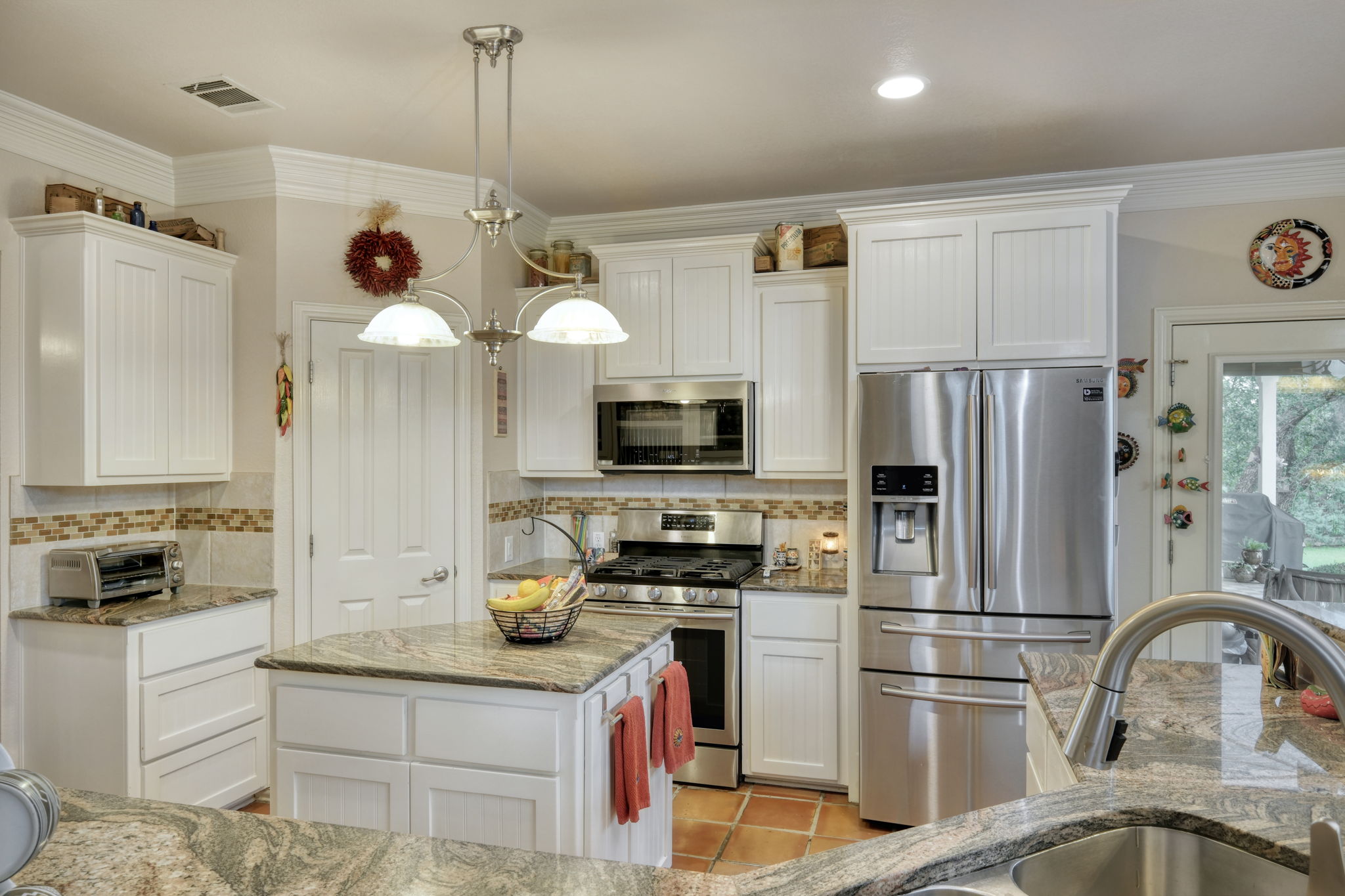1601 Coronado Leander, TX 78641 - Photo 12 of 37 a kitchen with refrigerator a microwave a stove and white cabinets