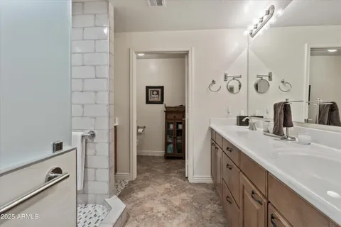 a spacious bathroom with a double vanity sink a mirror and shower