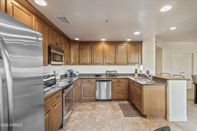 a kitchen with stainless steel appliances granite countertop a sink stove and refrigerator