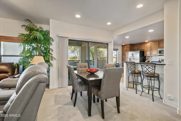 a living room with furniture and a dining table with kitchen view