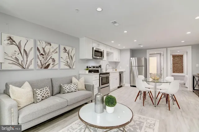 a living room with furniture and kitchen view