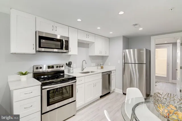 a kitchen with stainless steel appliances a white stove top oven and refrigerator