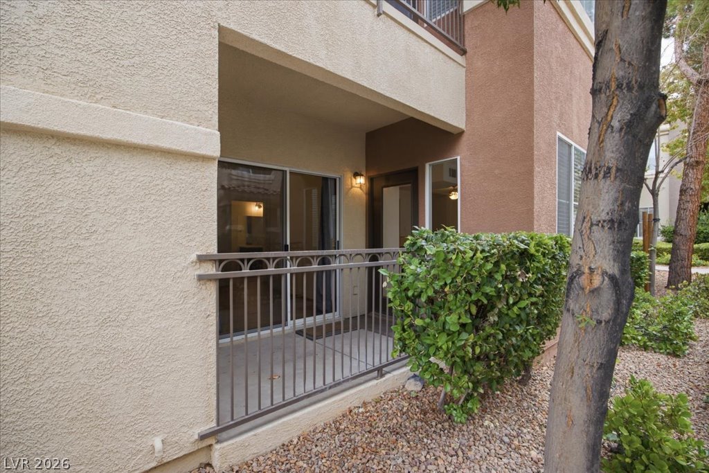 9050 West Warm Springs Road, Unit 1033 Las Vegas, NV 89148 - Photo 18 of 26 Secure ground-level patio access, framed by manicured shrubs and durable railing.