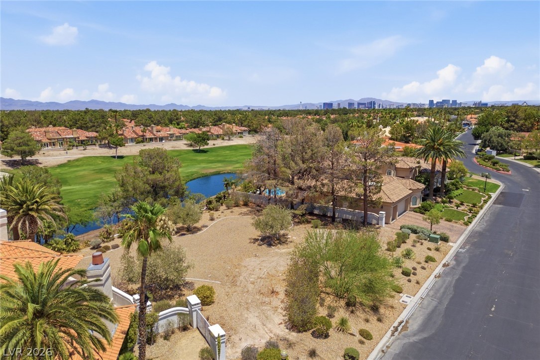 20 Innisbrook Avenue Las Vegas, NV 89113 - Photo 9 of 39 Aerial view showcasing a pristine golf course, shimmering pond, and luxurious homes under a vast sky.