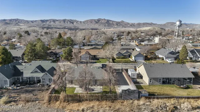 an empty room with wooden floor chandelier and windows