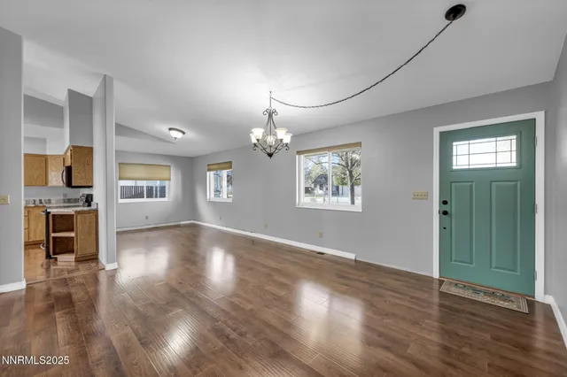 a kitchen with stainless steel appliances granite countertop wooden floor a stove a sink and a refrigerator