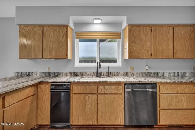 a kitchen with granite countertop cabinets stainless steel appliances and a sink