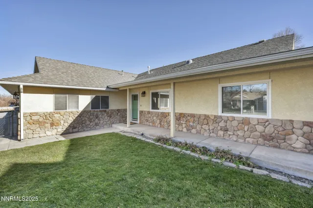 a backyard of a house with table and chairs