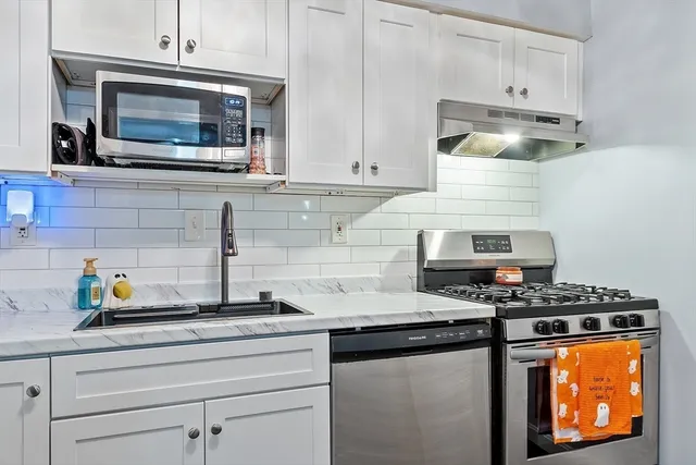 a kitchen with stainless steel appliances granite countertop a stove and a microwave