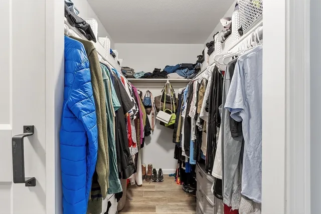 a view of walk in closet with clothes and shoes