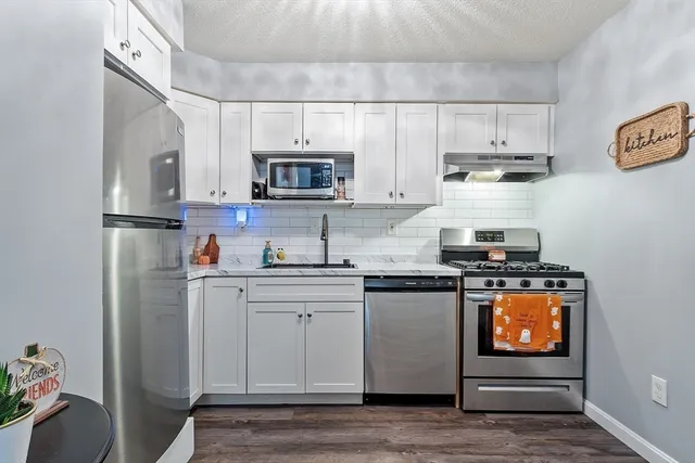 a kitchen with stainless steel appliances a stove a sink and a refrigerator