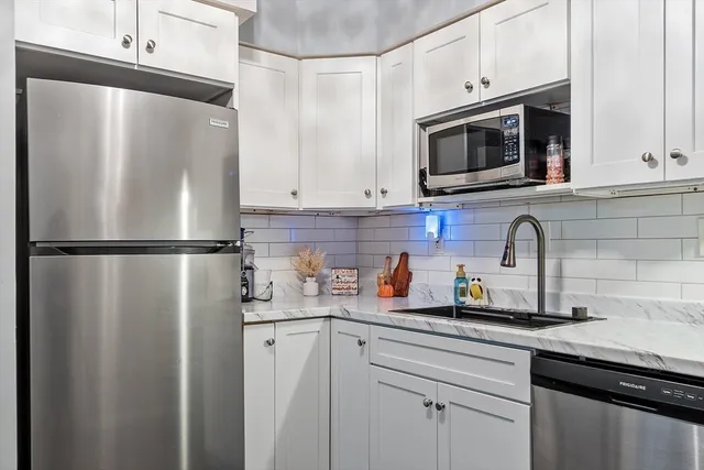 a kitchen with stainless steel appliances a refrigerator sink and cabinets
