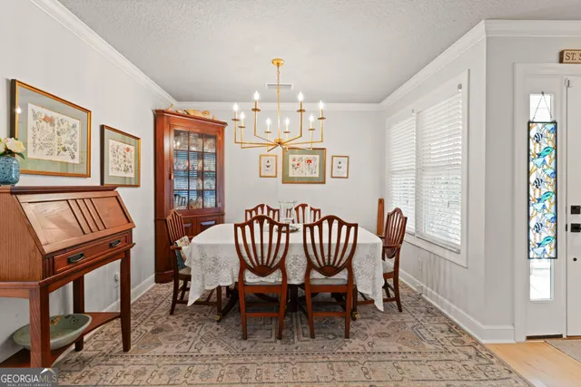 a view of a dining room with furniture a chandelier and wooden floor