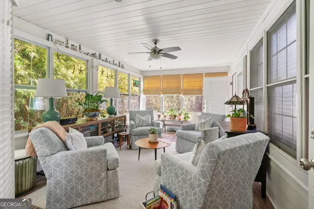 a living room with patio furniture and a large window