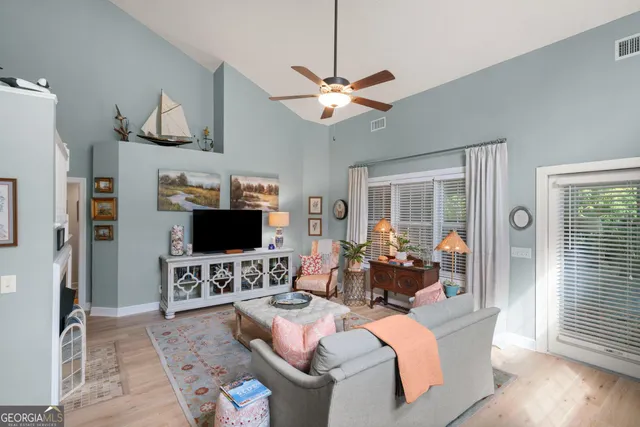 a living room with furniture a ceiling fan and a window