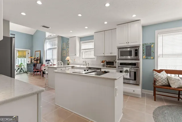 a kitchen with stainless steel appliances a stove a sink dishwasher a oven and a refrigerator with wooden floor