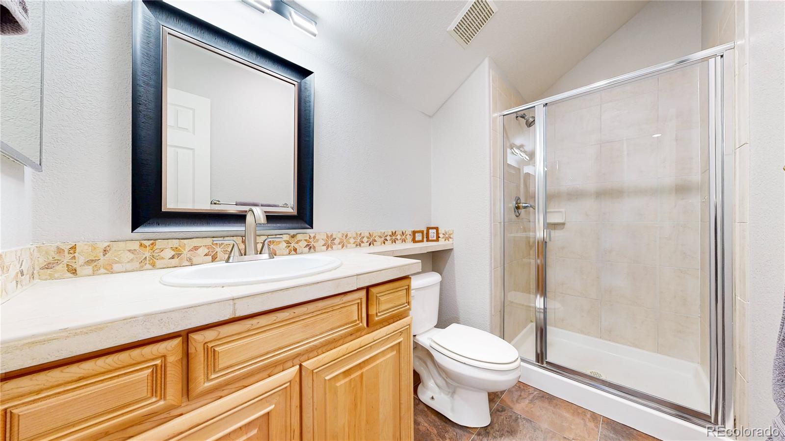 4545 South Monaco Street, Unit 138 Denver, CO 80237 - Photo 20 of 34 a bathroom with a sink a toilet a mirror and shower