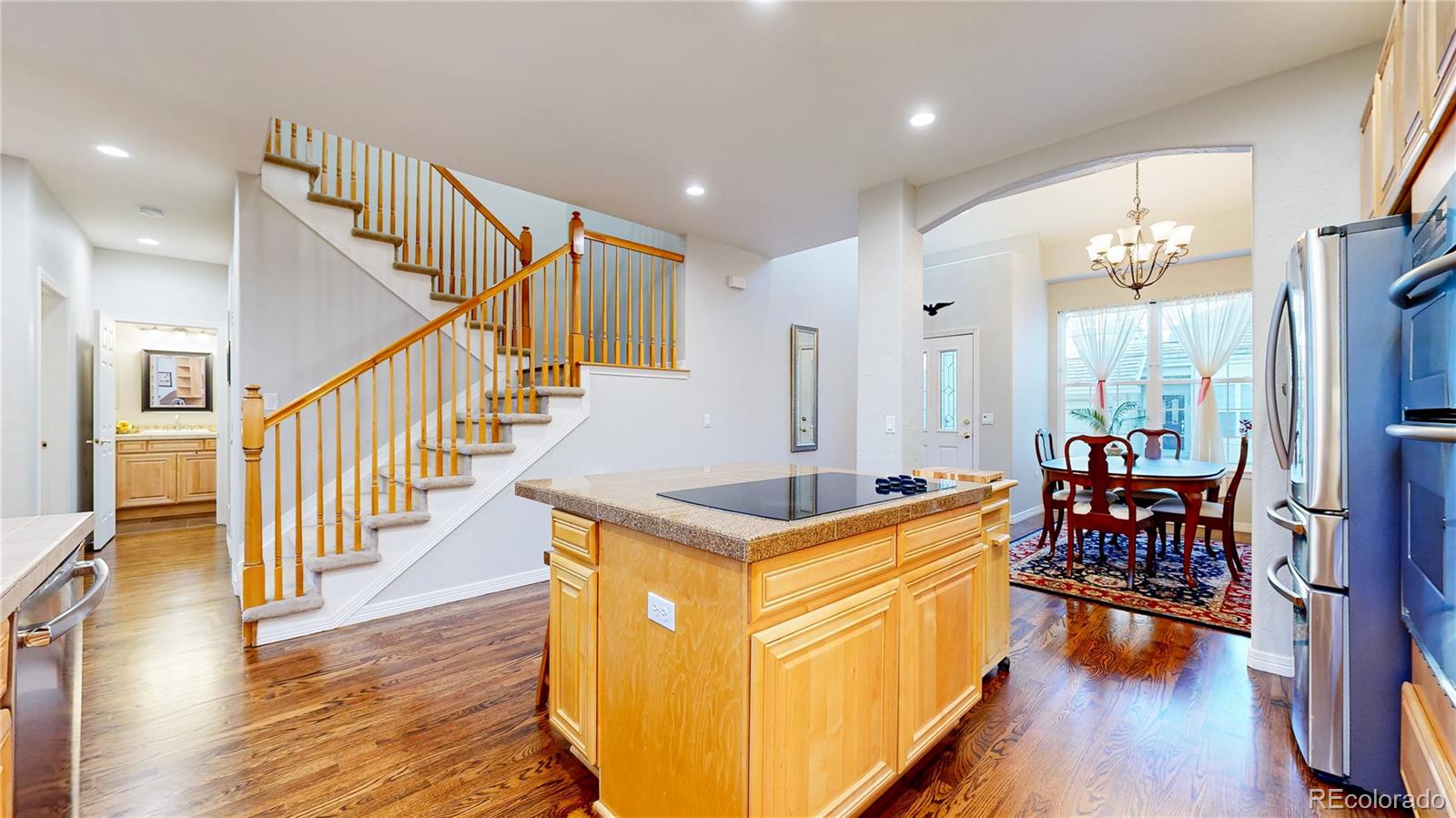 4545 South Monaco Street, Unit 138 Denver, CO 80237 - Photo 8 of 34 a kitchen with stainless steel appliances granite countertop center island wooden floor and a view of living room